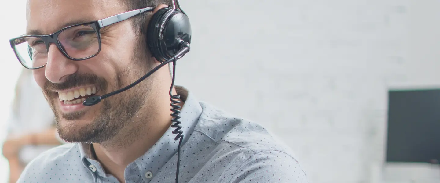 Mann mit Headset an einem Schreibtisch