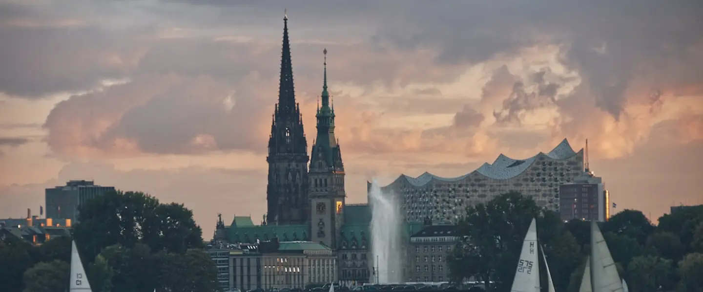 Blick über die Alster auf das Hamburger Rathaus und die Elbphilharmonie in der Abenddämmerung